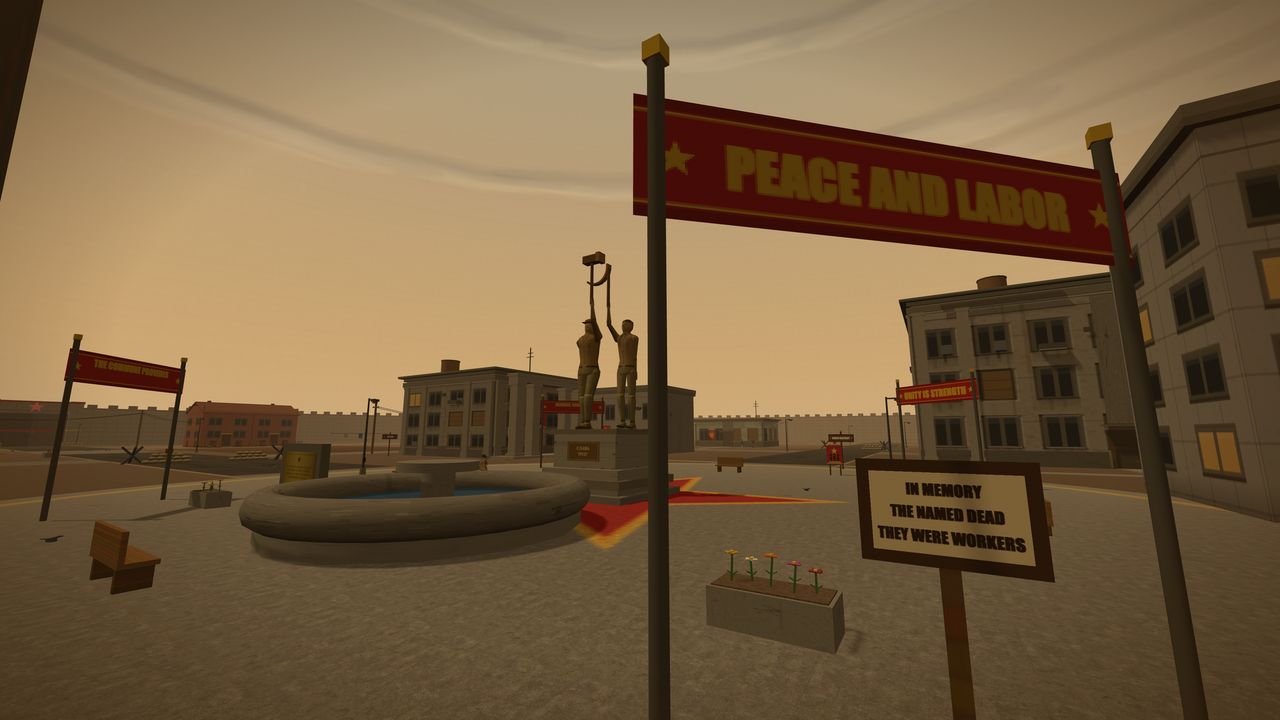 A wide plaza at dusk beneath a red banner lettered PEACE AND LABOR in gold, flanked by gold stars. Behind it a bronze statue of two workers raises a hammer and sickle above a stone plinth. A dry circular fountain with a patch of blue water sits to the left, a red carpet runs to the statue steps, and a hand-lettered board in the right foreground reads IN MEMORY / THE NAMED DEAD / THEY WERE WORKERS. Smaller banners across the square read THE COMMUNE PROVIDES and UNITY IS STRENGTH, with apartment blocks, a planter of flowers and the settlement's perimeter wall beyond.